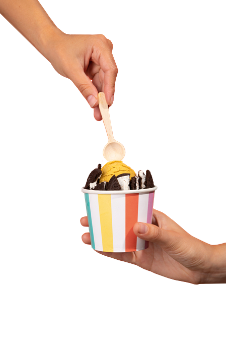 Garnierter Eisbecher in der Hand, in den ein Löffel gesteckt wird